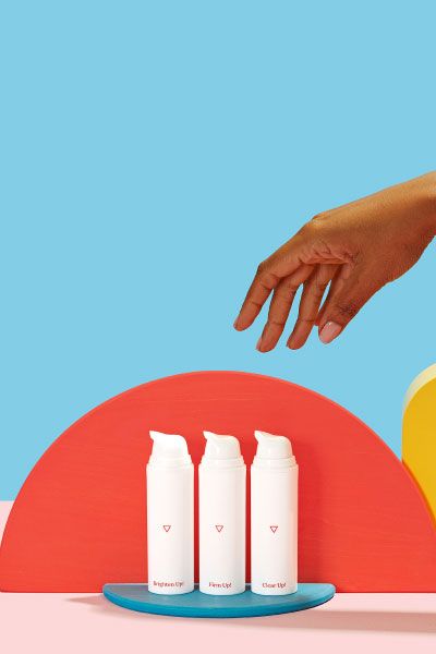 Hand reaching for bottles of Wisp Even Out! Hydroquinone for Body cream