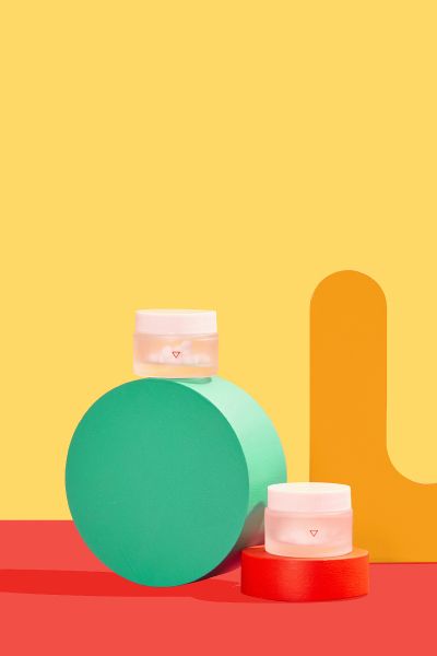 Wisp pill bottles with colorful abstract shapes on a yellow and red background