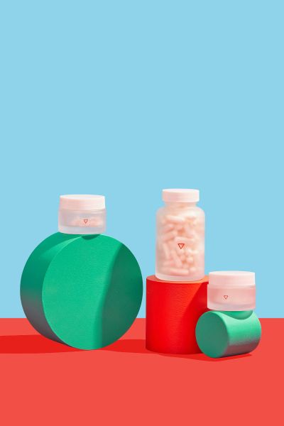 Wisp pill bottles sit on colorful geometric shapes with a red and blue background