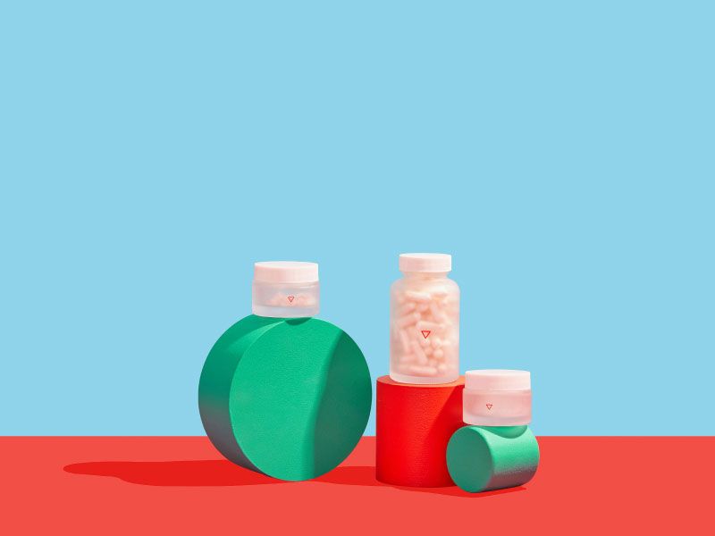 Wisp pill bottles sit on colorful geometric shapes with a red and blue background