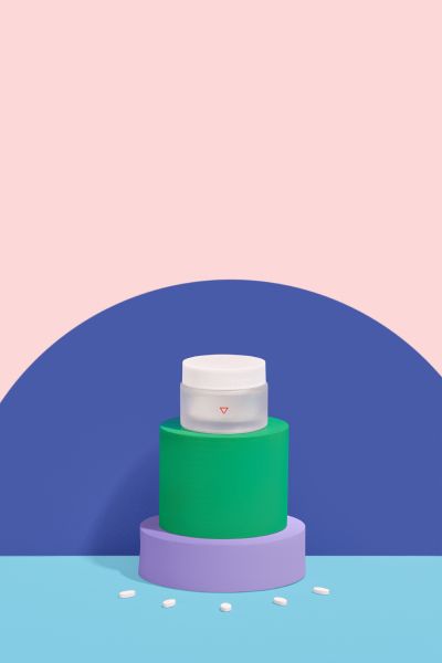 Wisp pill bottle with colorful organic shapes on a pink and blue background