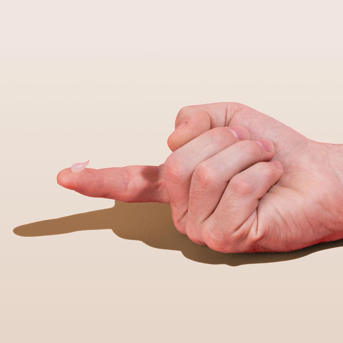 Hand with Acyclovir cream on index finger to treat oral and genital herpes on a cream background