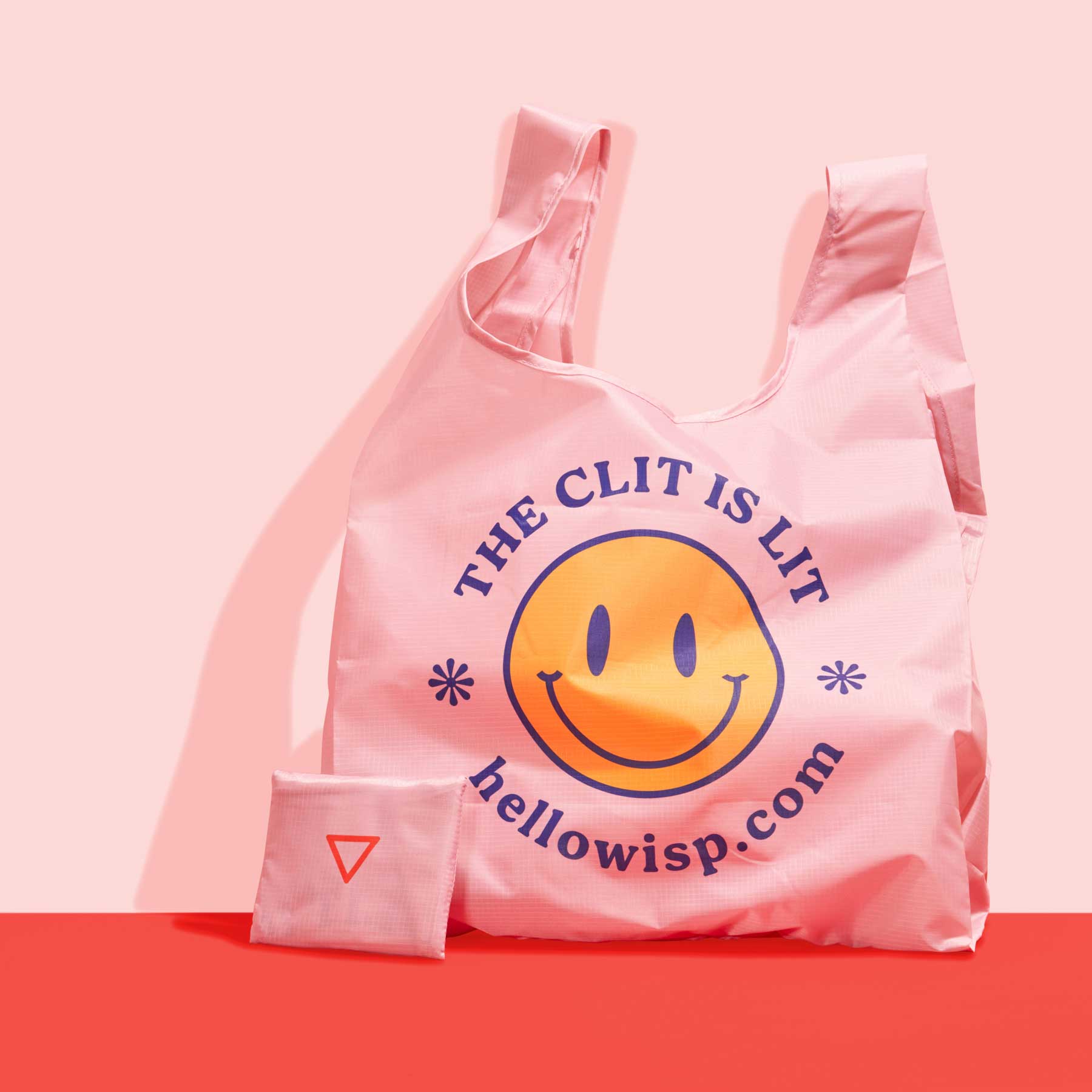 Wisp clit is lit tote on a pink and red background