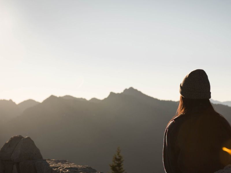 a woman meditating on a mountain