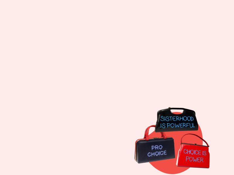 3 Michele Pred handmade purses with abortion rights statements on them on a red and cream-colored background