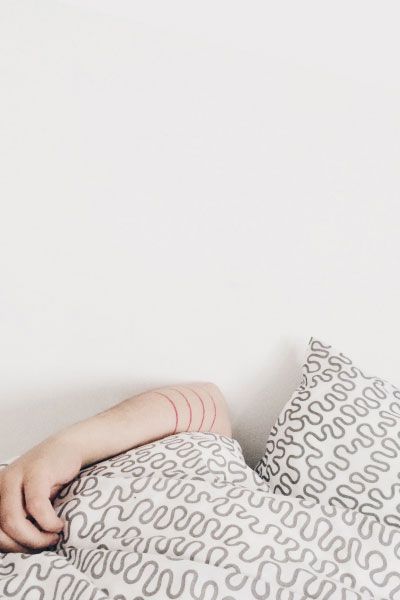 person's arm resting on bedding with a fun geometric pattern