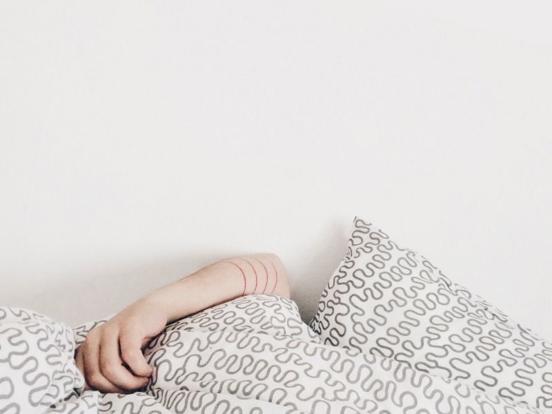 person's arm resting on bedding with a fun geometric pattern