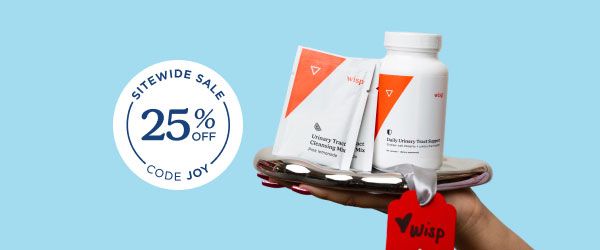 A person's hand holding a silver tray with Wisp UTI medication on it in front of a light blue background