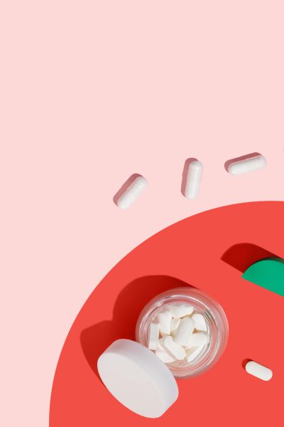 Top down image of wisp jars with pills in them surrounded by colorful abstract shapes on a pink background