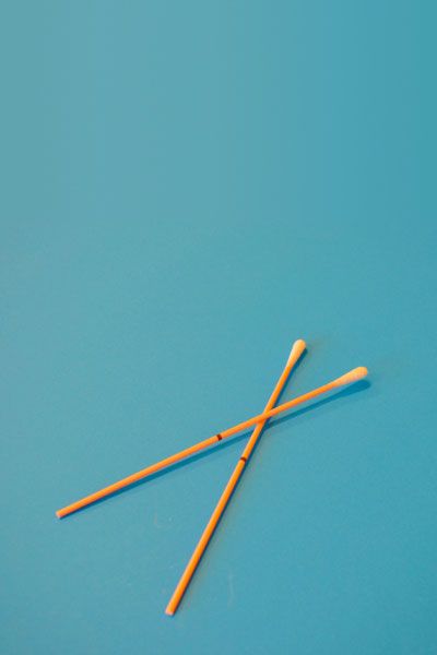 Orange test swabs on a teal-colored background