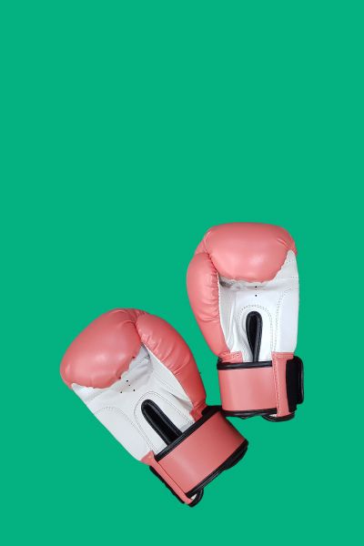 Pink boxing gloves on a green surface