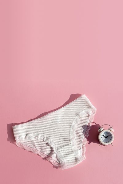 White underwear with a white alarm clock on a pink background