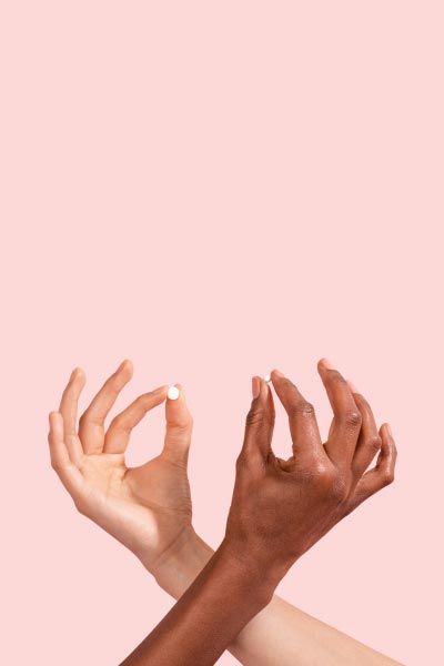 Two female hands criss crossing, both holding an Emergency Contraception pill in front of a pink background