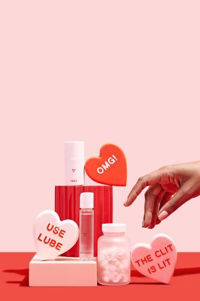 Large colorful hearts with Wisp OMG Cream and Harmonizing Lube with colorful blocks on a pink and red background