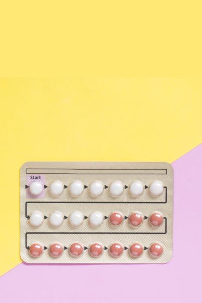 A birth control packet on a yellow and pink background