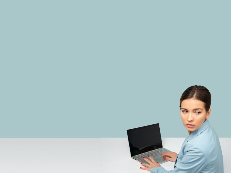 Woman sitting at a desk with a laptop looking worried