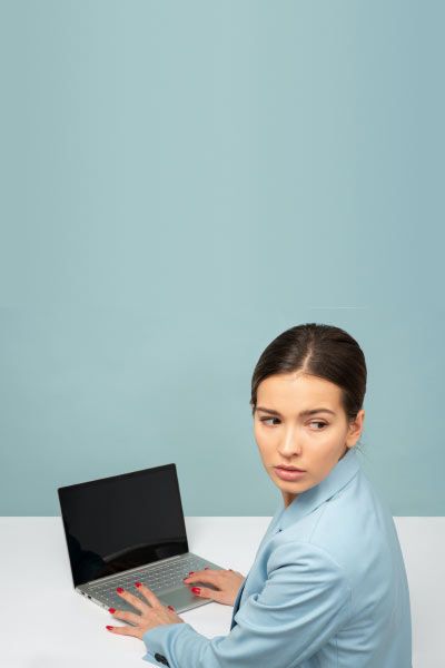 Woman sitting at a desk with a laptop looking worried
