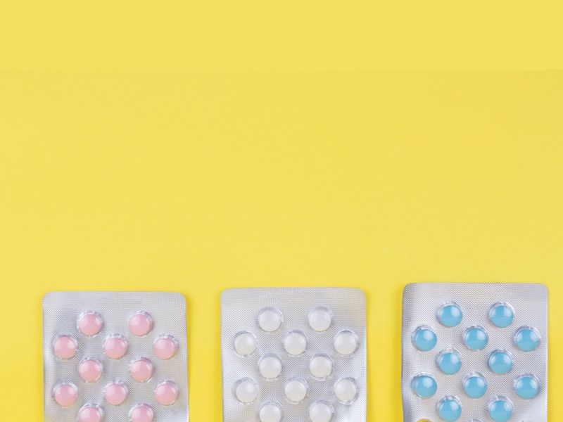 3 packets of colorful pills on a yellow background