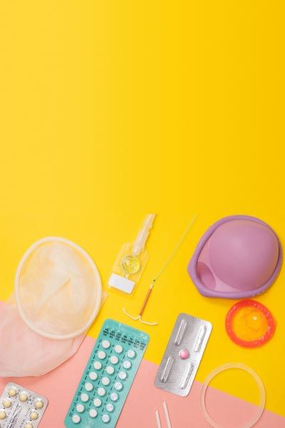 Multiple types of contraceptives on a yellow and pink background