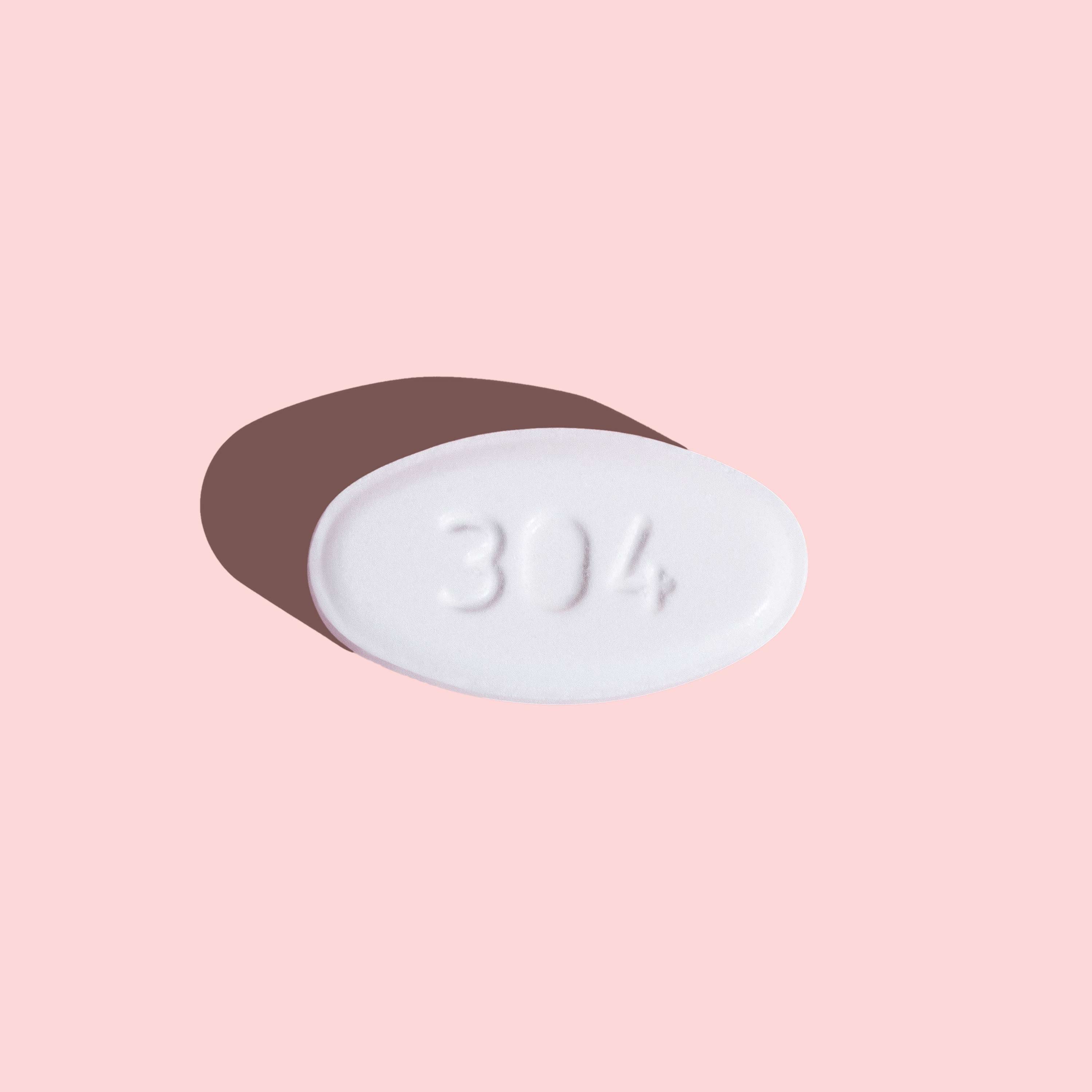 Single Norethindrone Acetate pill to delay your period on a pink background