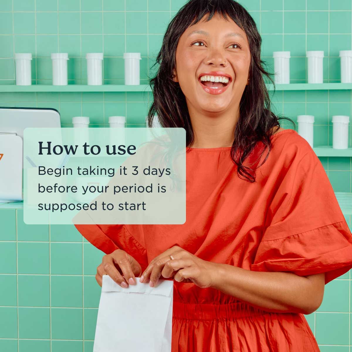 A happy woman wearing a red dress at a pharmacy picking up Wisp medications