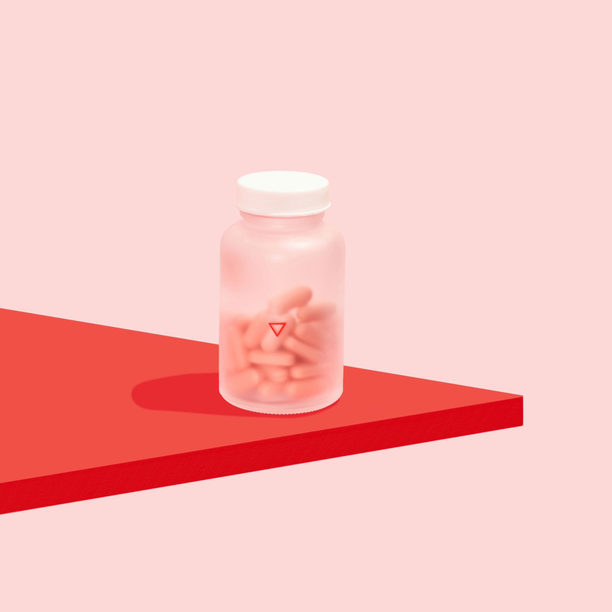 Wisp prenatal vitamins on a red surface with a pink background