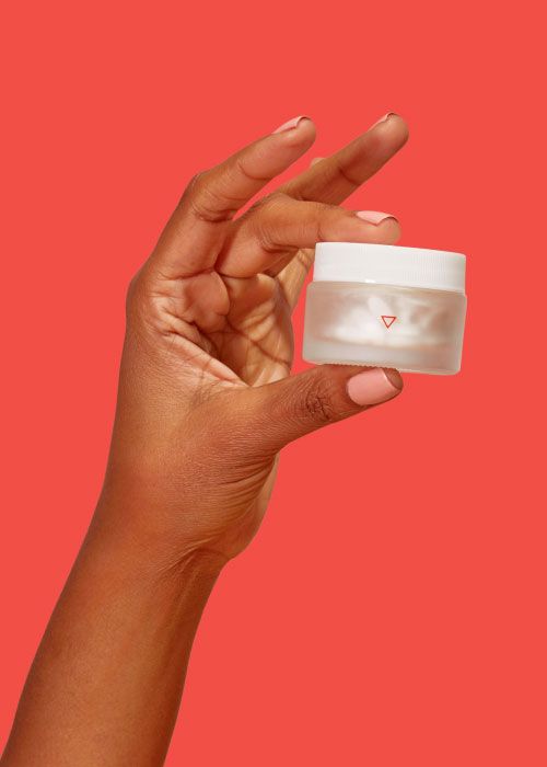 hands holding topical bacterial vaginosis treatment on a red background