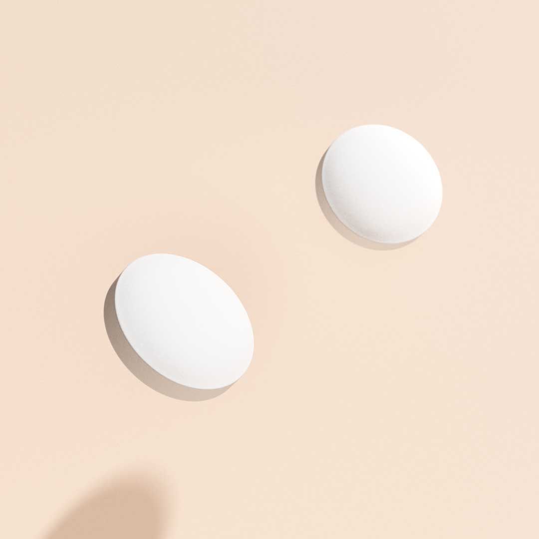 Ella emergency contraception pills floating above a cream surface