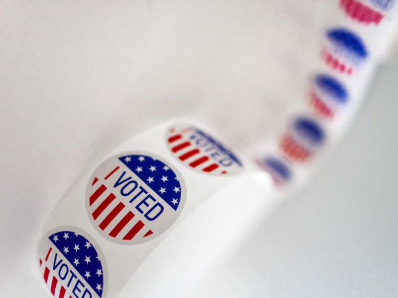 a roll of I Voted stickers on a white surface