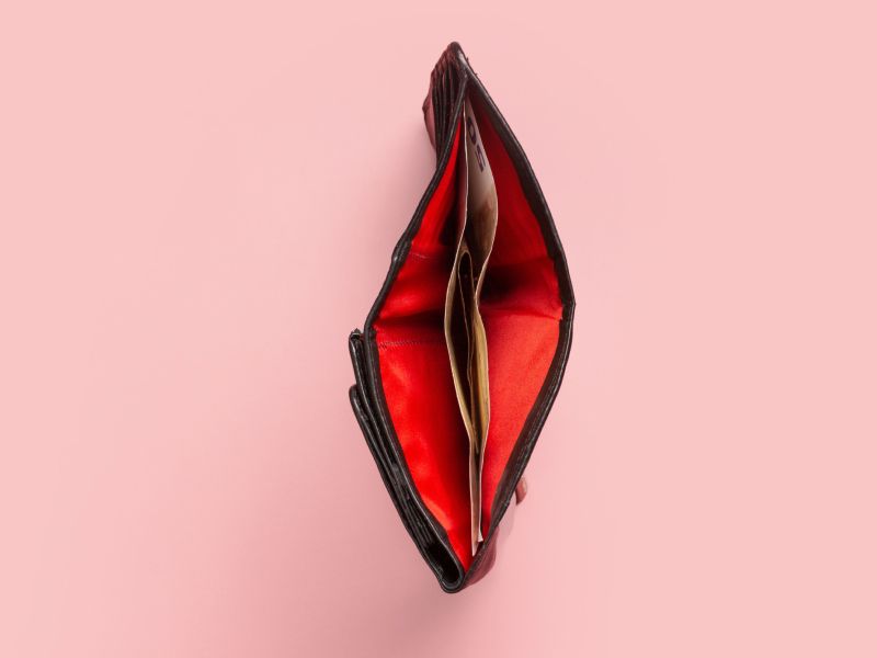 a red wallet open to look like a vulva on a pink background