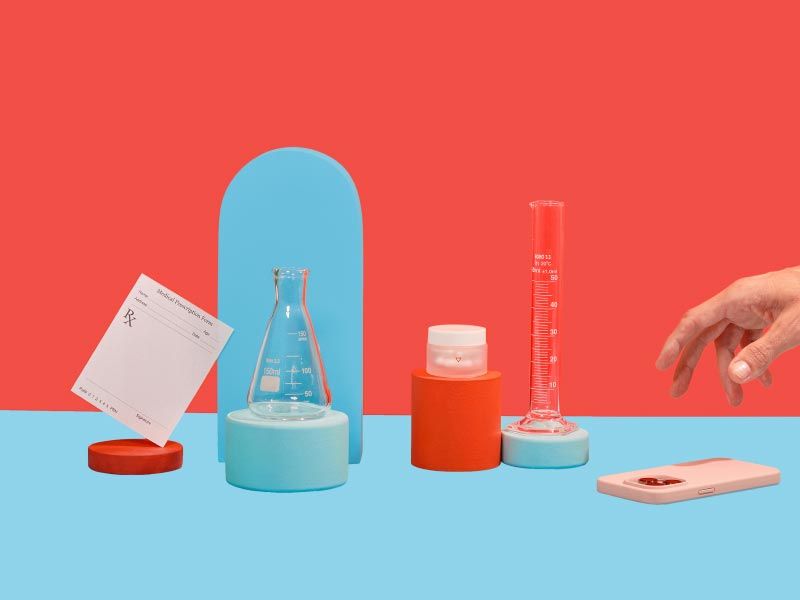 STD treatment meds and testing vials with an rx script and a hand reaching for a mobile phone on a red and light blue background