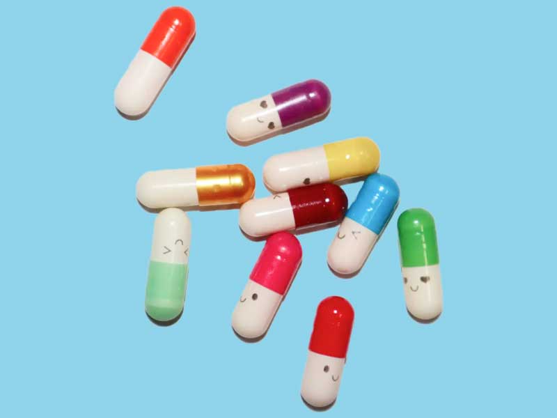 Colorful pills on a light blue surface