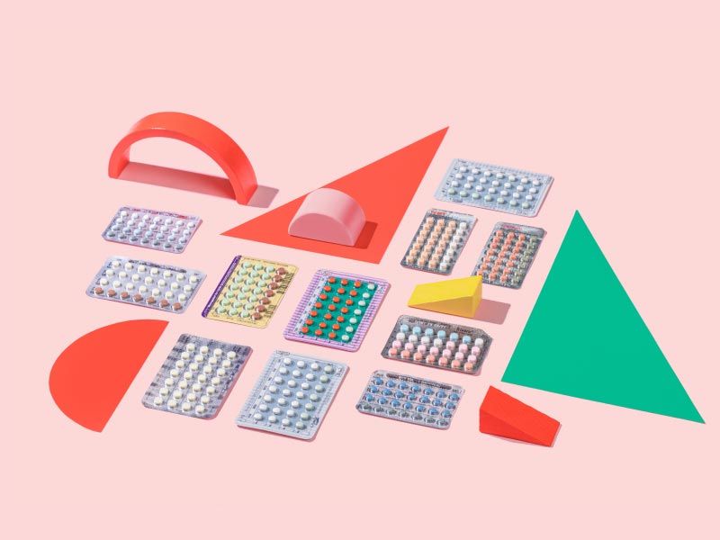 Several colorful birth control packets with colorful abstract shapes on a pink background
