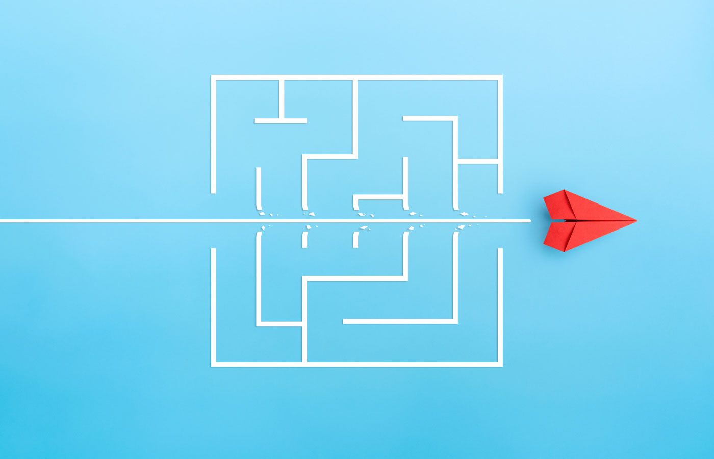 A red paper plan cutting through a white maze on a light blue background