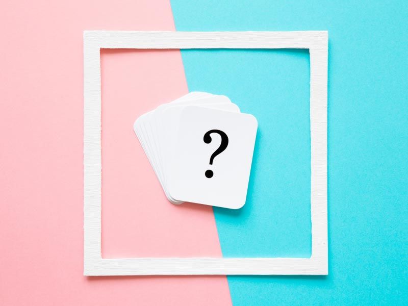 A question mark inside a white frame on a pink and light blue background