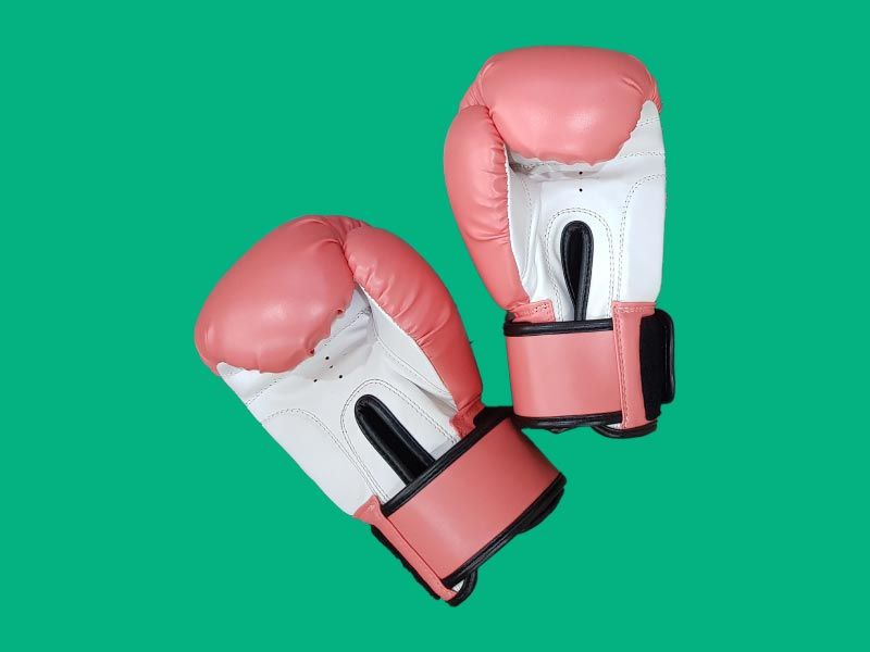 Pink boxing gloves on a green surface