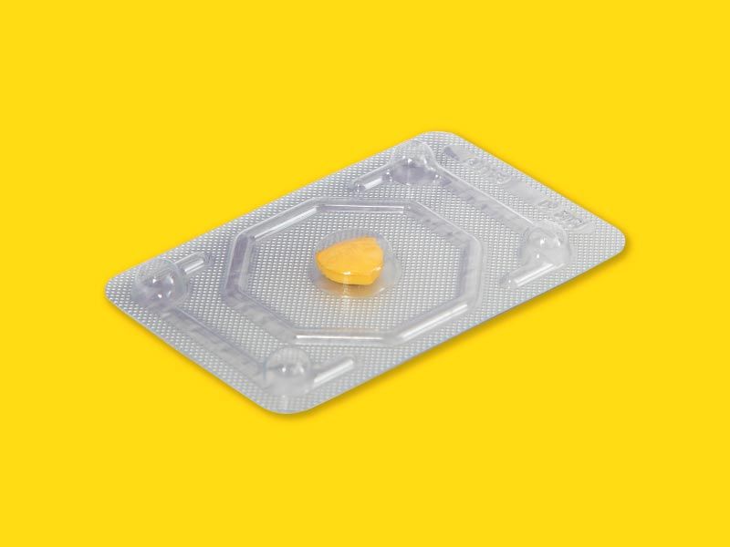 An emergency contraception packet laying on a yellow surface