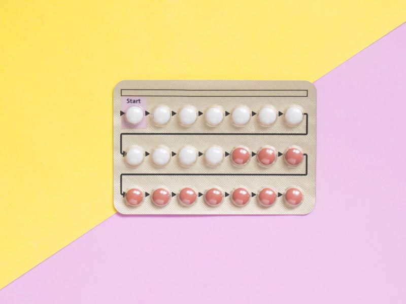 A birth control packet on a yellow and pink background