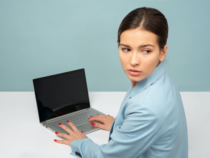 Woman sitting at a desk with a laptop looking worried