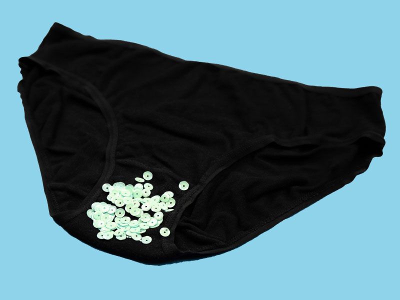 Black underwear with glitter sprinkled on them with a light blue background