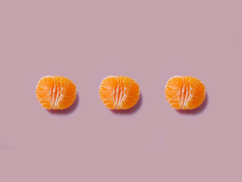 3 halved oranges on a mauve background