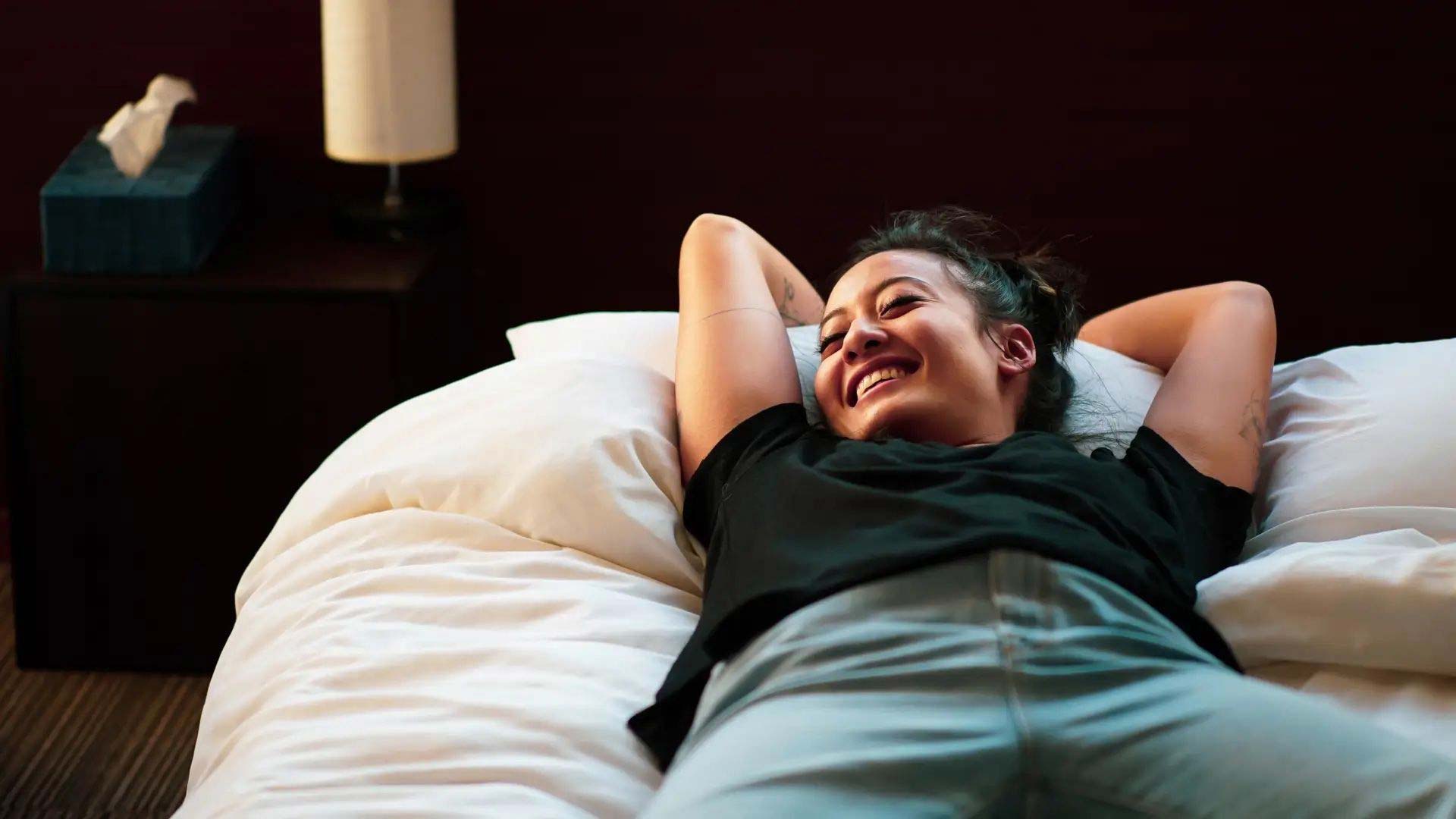 smiling woman laying on bed