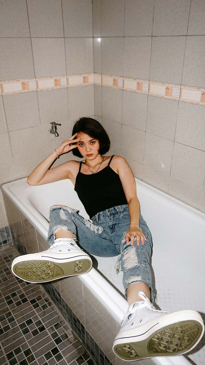 a woman sitting in a bathtub fully clothed