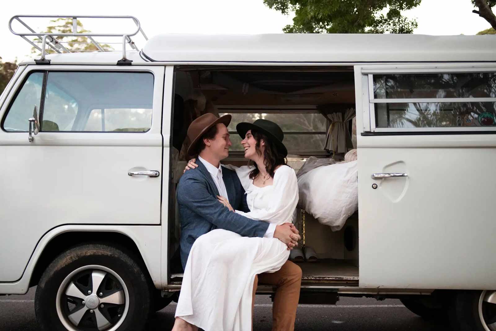Newlywed couple sitting in a white van