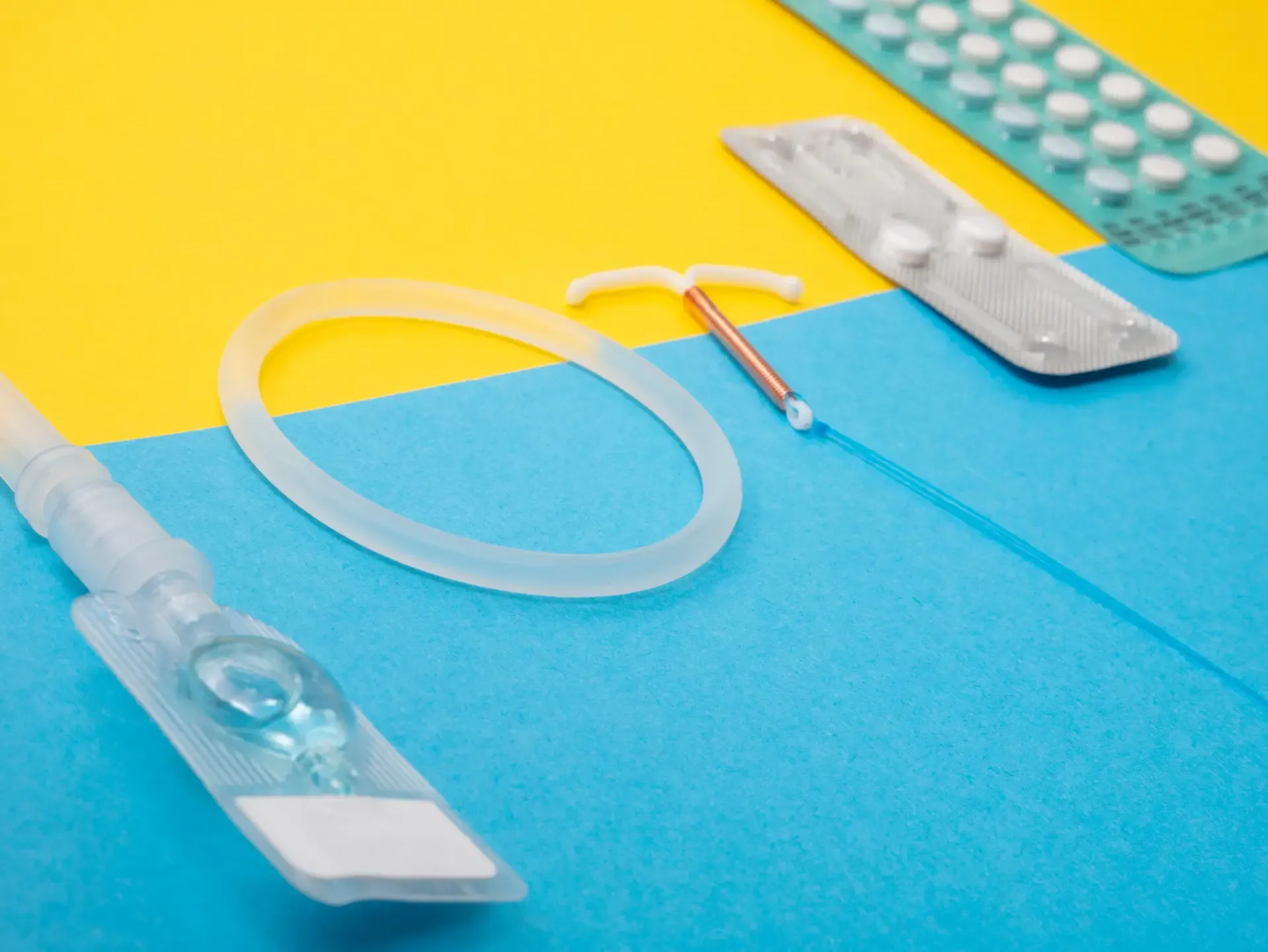 various methods of contraception including birth control pills, morning after pill, and IUD on a blue and yellow background