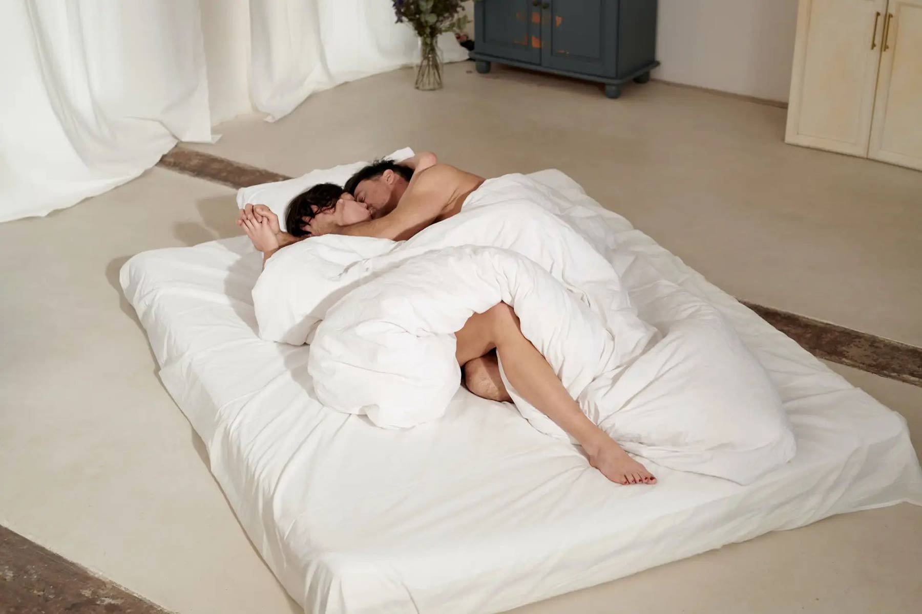 a couple lying in bed intertwined 