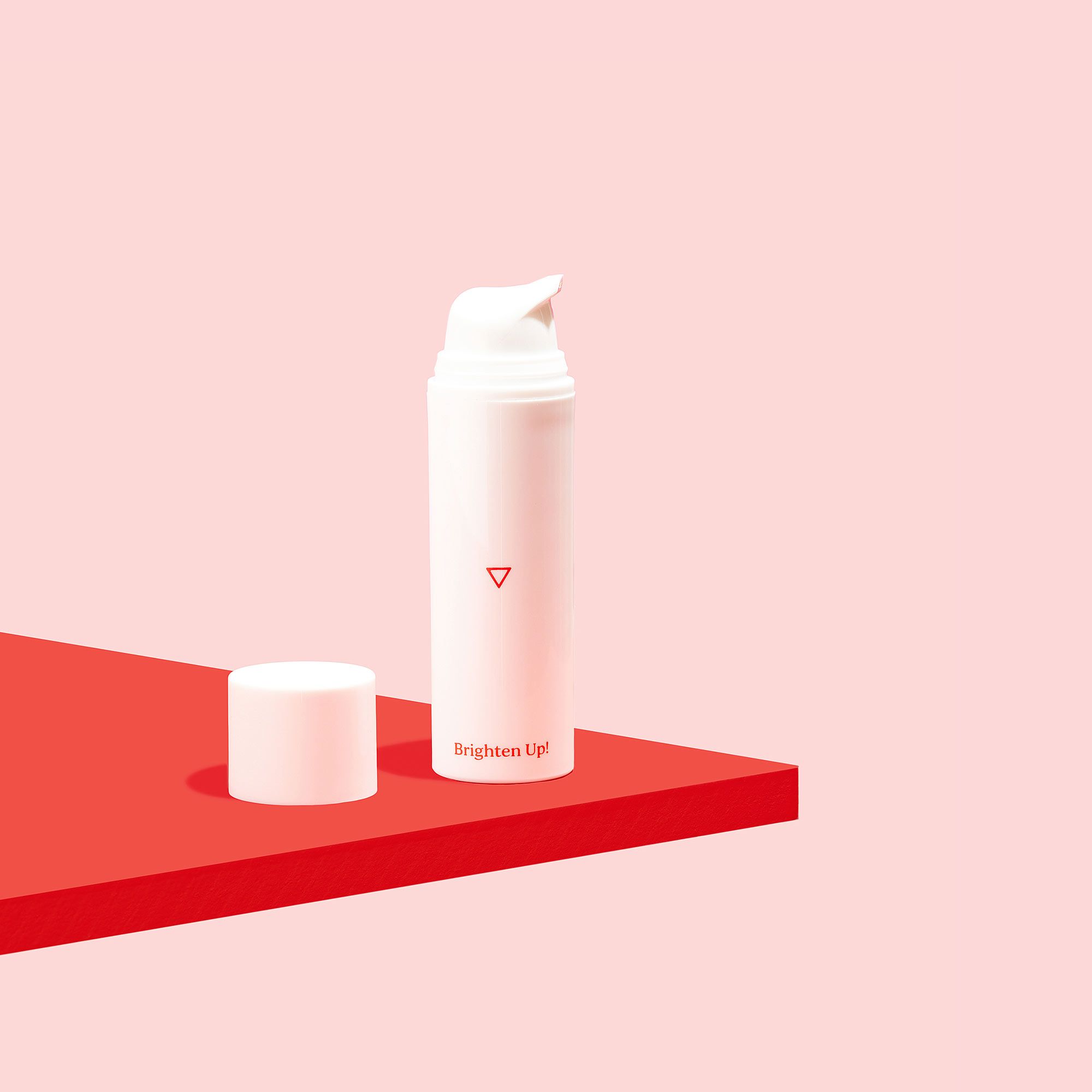 Bottle of Brighten Up! Hydroquinone Cream for hyperpigmentation on a red surface, on a pink background