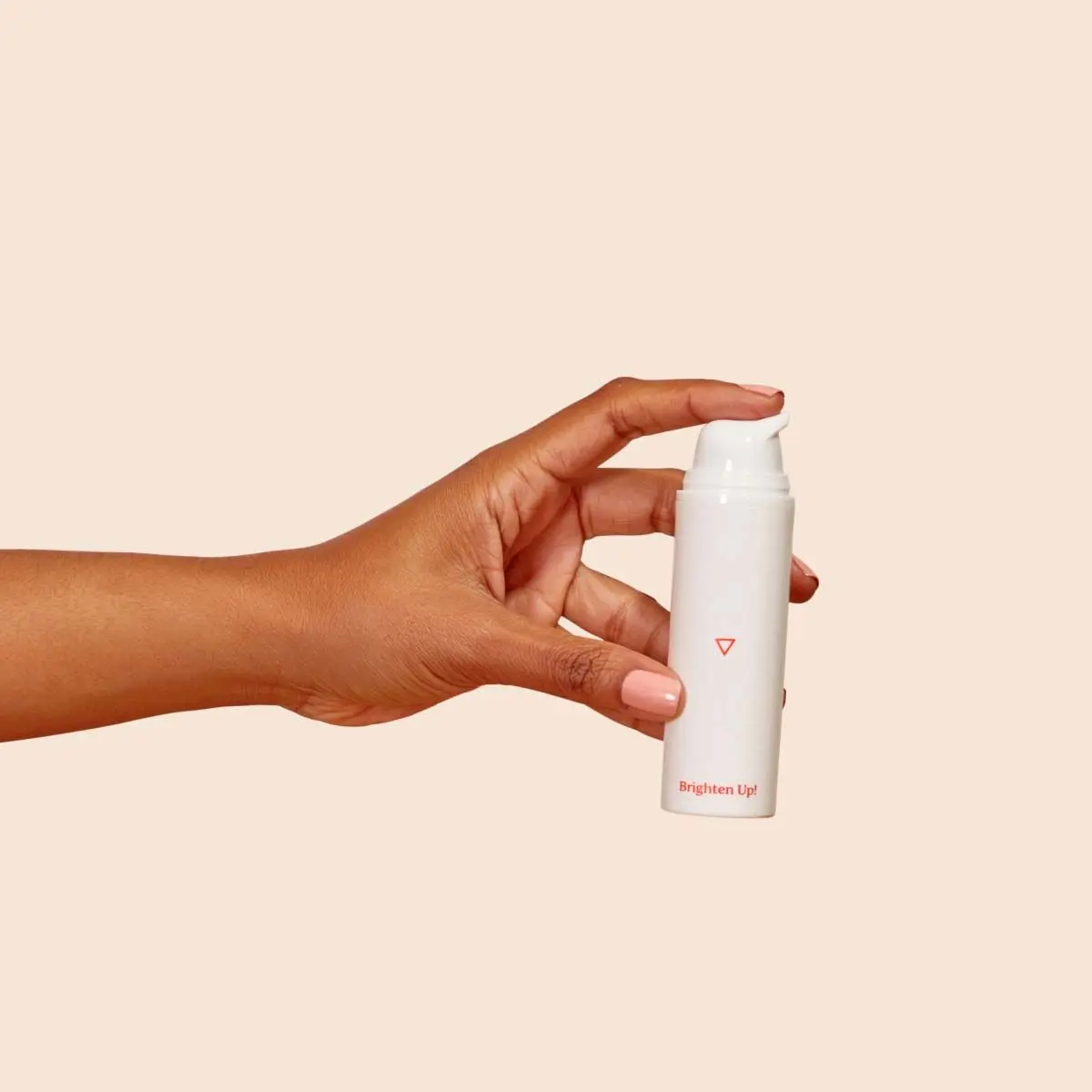 Bottle of Brighten Up! Hydroquinone Cream in a person's hand with a cream background