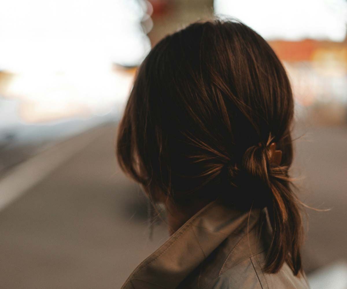 A close up motion blur of a woman with dark hair on a city street