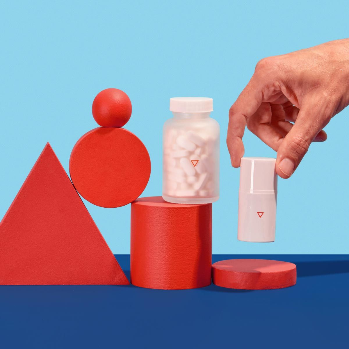 a man's hand reaches for Wisp prescription Genital Herpes treatment and prevention on a blue and red geometric background